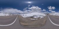 the camera lens is on as the road curves through the snow bank to the viewer