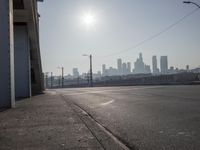 view of city from an open empty road at the intersection of a highway, with cars parked along it