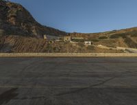 a building in the middle of the mountain range with a large rock wall on both sides