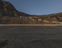 a building in the middle of the mountain range with a large rock wall on both sides