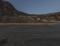 a building in the middle of the mountain range with a large rock wall on both sides