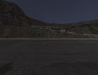 a building in the middle of the mountain range with a large rock wall on both sides