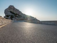 the sun is setting on a large hill overlooking a mountain slope with the road going up it