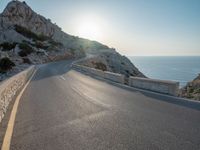 the sun is setting on a large hill overlooking a mountain slope with the road going up it