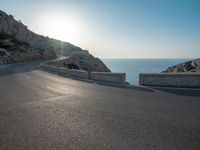 the sun is setting on a large hill overlooking a mountain slope with the road going up it