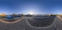 two fisheye shots of a view over a city from the top of a bridge