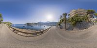 a fish eye view of a coastal beach side area with the sun rising over the water