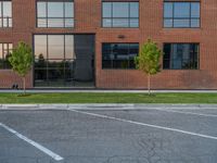 an empty street in front of a large red brick building on the other side of the road is a street light that has a line for motorists