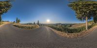 a panorama lens that is showing the sun coming up on a road and an empty street