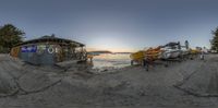 a group of boats parked on the beach at sunset in the bay area of a shore, with the sun in the distance