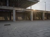 a small fire hydrant on the ground by a building with benches and steps at sunset