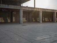 a small fire hydrant on the ground by a building with benches and steps at sunset