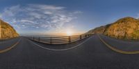 a curved bridge over an ocean at sunset near the ocean shore is shown with a fish eye lens