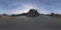 a skateboarder riding the ramp at sunset by a rocky hill on a mountain