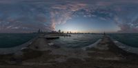 a photo of a pier on the beach at sunset with cityscape in the background