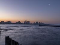 the city skyline is shown at sunset in this image of this photo, the water is empty