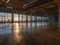 the sun setting in the building is seen through the windows and floor glass doors of the room