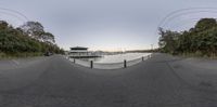 a fish eye view of a lake and the pier with boats and water at sunset