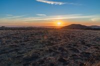 the sun shines brightly in the desert at sunset with a large field of dry grass