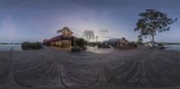 a fish - eye view of a dock with buildings on it at sunset and water flowing under