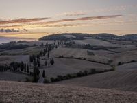 an empty field with a castle in the background at sunset in italy by steve berkell