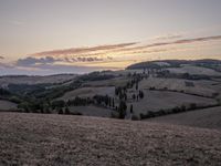 an empty field with a castle in the background at sunset in italy by steve berkell