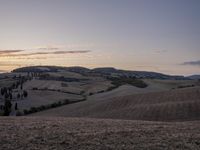 an empty field with a castle in the background at sunset in italy by steve berkell