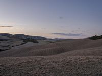 an empty field with a castle in the background at sunset in italy by steve berkell