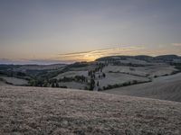 an empty field with a castle in the background at sunset in italy by steve berkell