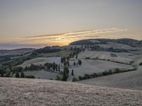 an empty field with a castle in the background at sunset in italy by steve berkell