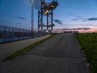 a view of the highway and some fenced off area of an airport during sunset