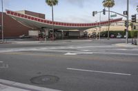 a street intersection with red stripes and palm trees in the background at sunset time,