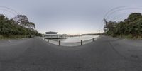 a fish eye view of a lake and the pier with boats and water at sunset