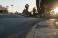 a stop sign on a corner by a road during the sunset light in california city