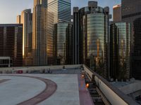 cityscape and skyscrapers at sunset viewed from the roof of a building with lots of windows