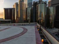 cityscape and skyscrapers at sunset viewed from the roof of a building with lots of windows