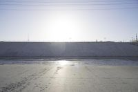 the sun is setting behind a large dam of water behind a wall on a highway