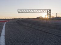 a person is riding a motorcycle down the track at sunset in a racetrack track with no running cars on it