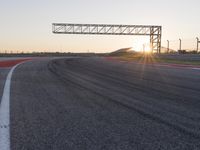 a person is riding a motorcycle down the track at sunset in a racetrack track with no running cars on it