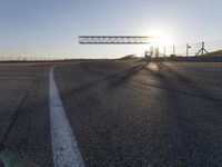 a person is riding a motorcycle down the track at sunset in a racetrack track with no running cars on it