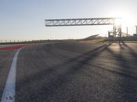 a person is riding a motorcycle down the track at sunset in a racetrack track with no running cars on it