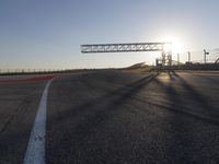 a person is riding a motorcycle down the track at sunset in a racetrack track with no running cars on it