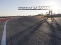 a person is riding a motorcycle down the track at sunset in a racetrack track with no running cars on it