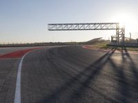 a person is riding a motorcycle down the track at sunset in a racetrack track with no running cars on it