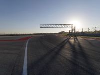 a person is riding a motorcycle down the track at sunset in a racetrack track with no running cars on it