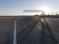 a person is riding a motorcycle down the track at sunset in a racetrack track with no running cars on it