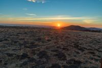 the sun is shining brightly on a sunset mountaintop with dry grass and scrubs