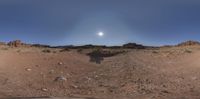 a sun is setting on the mountain and in front of the dirt field on top of the hill, in a 360 - effect photo