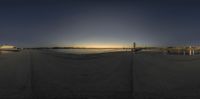 a view of a dock with sailboats and ships in the ocean with a setting sun