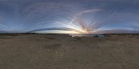 an image of the sun setting over the ocean from within it with some big clouds